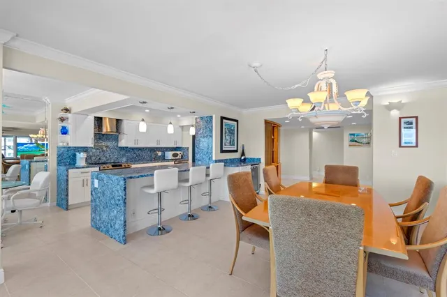 a kitchen with granite countertop a stove a sink a dining table and chairs