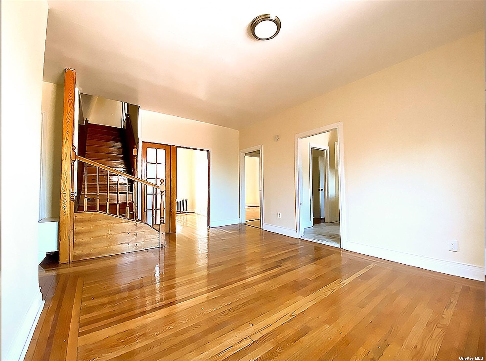 Undisclosed Address Queens, NY 11372 - Photo 11 of 18 a view of an empty room with wooden floor and a window