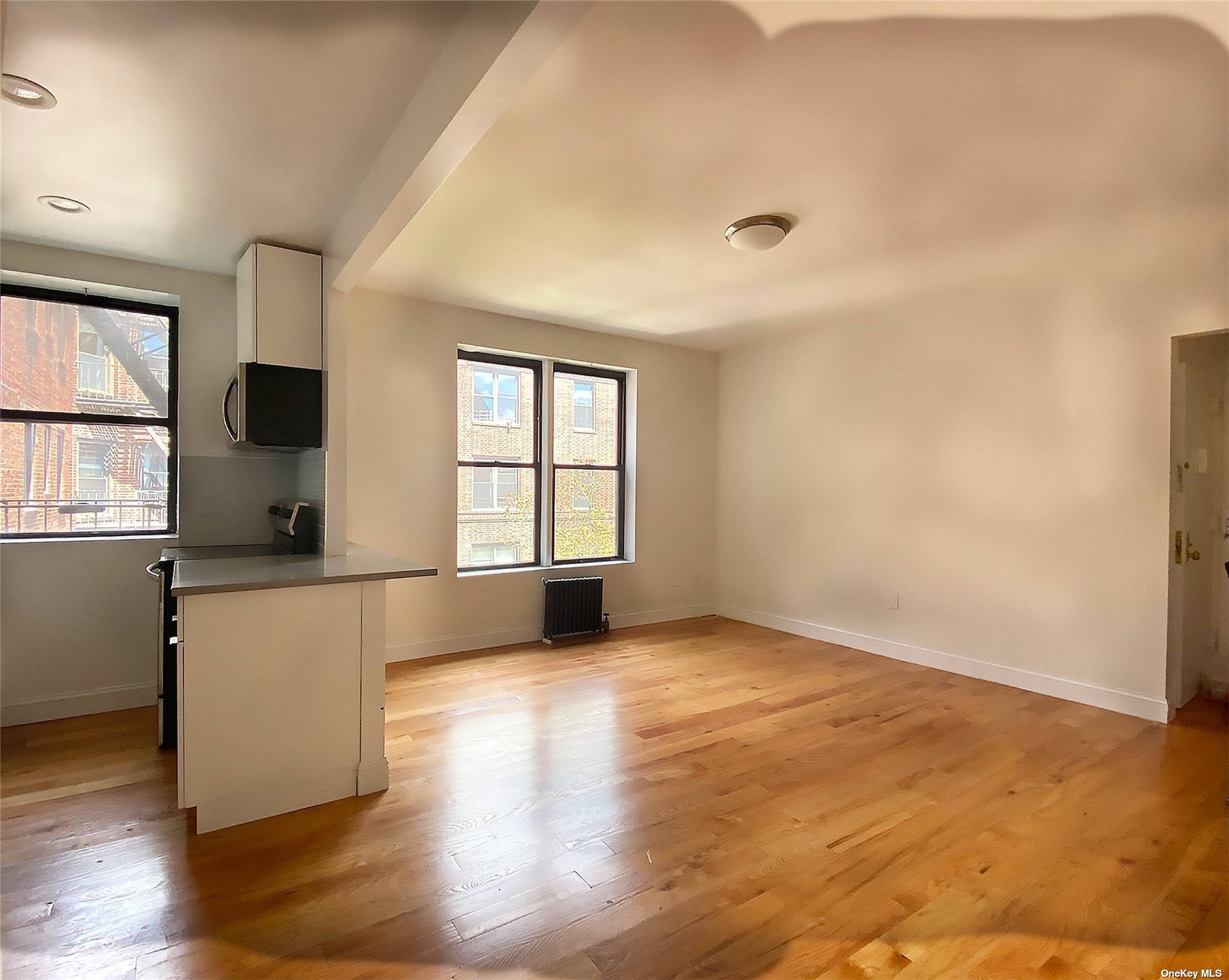 Undisclosed Address Queens, NY 11372 - Photo 12 of 18 an empty room with wooden floor and windows