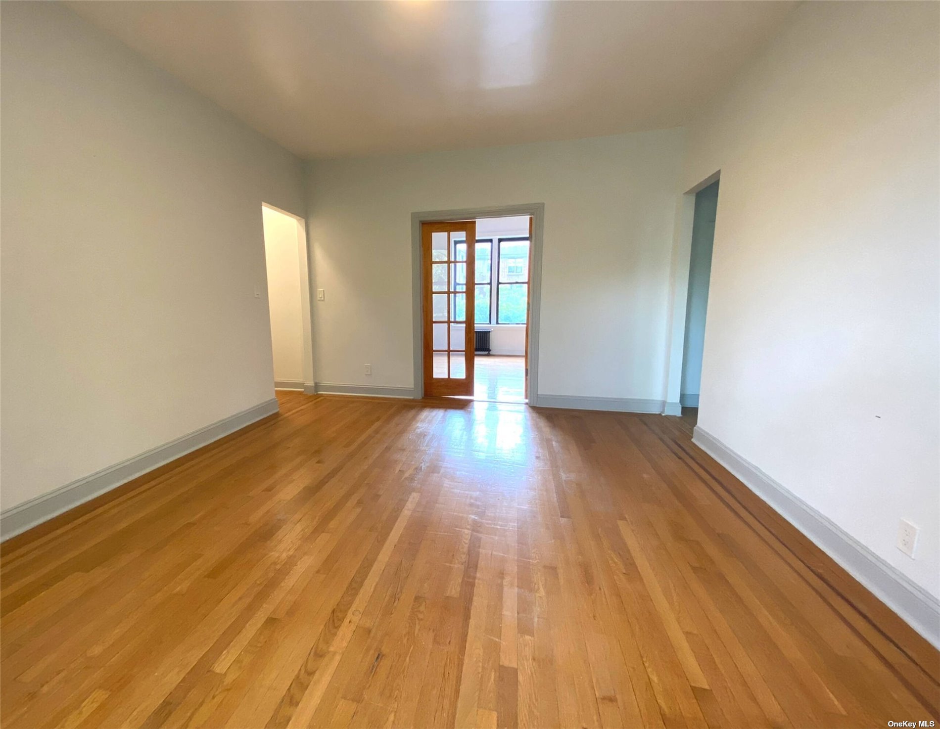 Undisclosed Address Queens, NY 11372 - Photo 13 of 18 a view of an empty room with wooden floor and a window