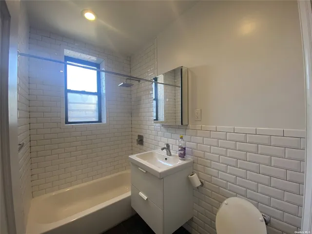 a bathroom with a sink mirror vanity and toilet