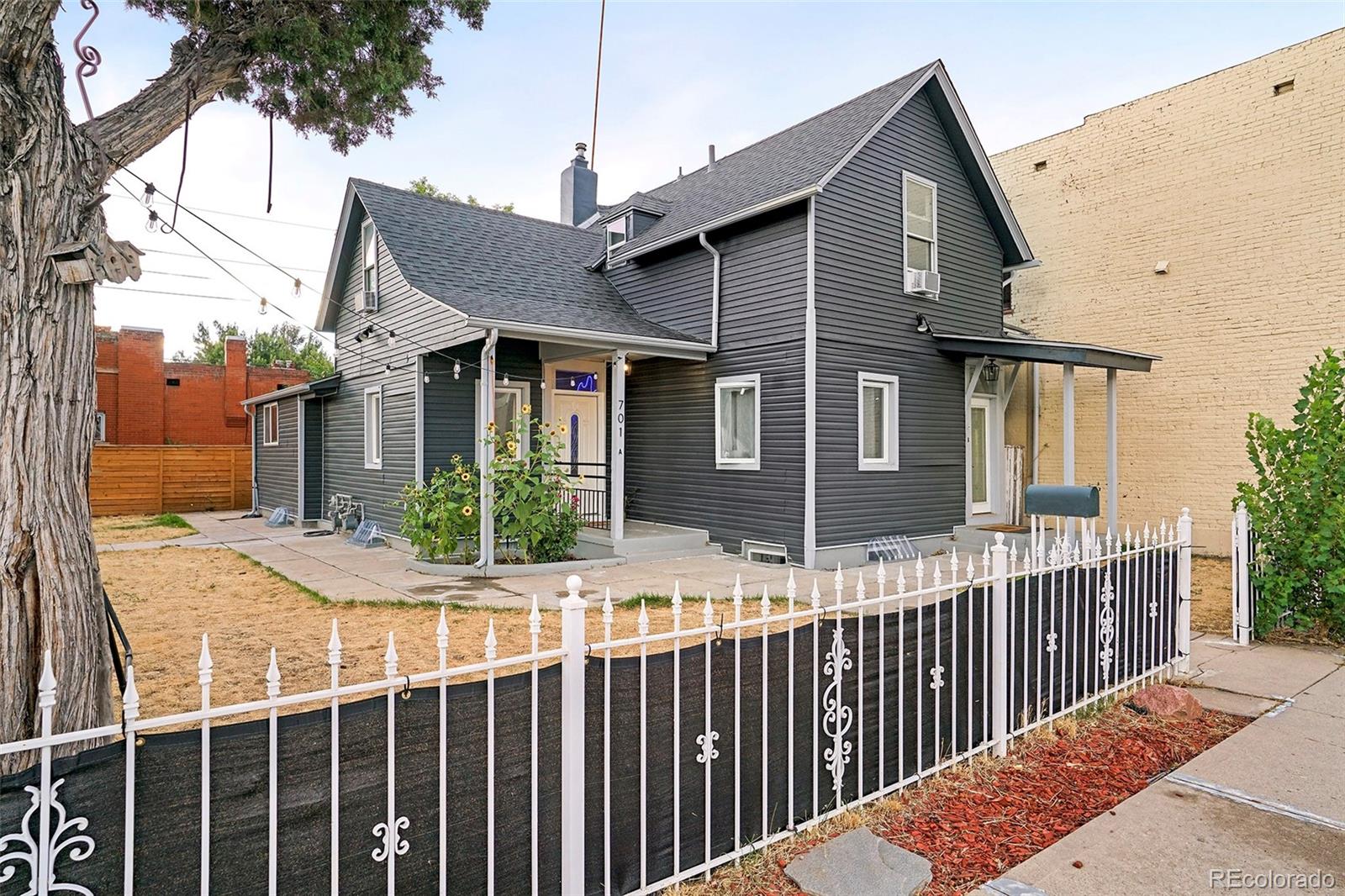 701 Galapago Street Denver, CO 80204 - Photo 2 of 38 a view of a house with wooden fence next to a road
