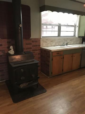 194 Pine Valley Loop Houston, AR 72070 - Photo 6 of 21 Wood-burning stove with a black pipe extending upwards