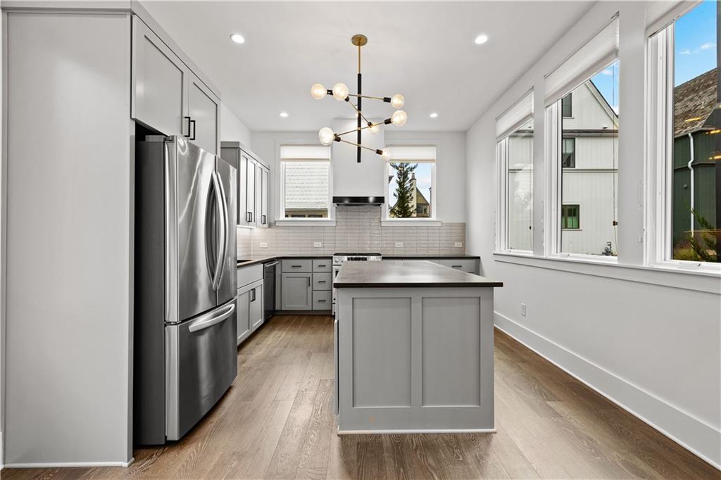 255 High Street Fayetteville, GA 30214 - Photo 11 of 67 a kitchen with granite countertop a refrigerator a sink and wooden floor