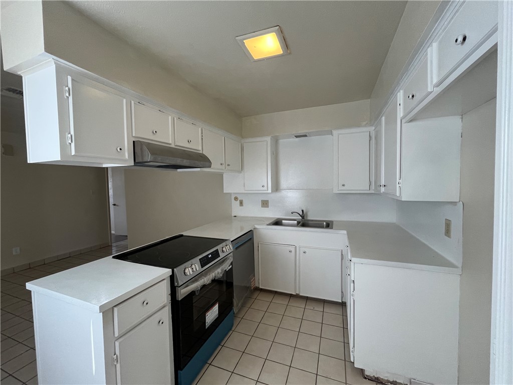 5002 Wingfoot Lane, Unit A Corpus Christi, TX 78413 - Photo 17 of 25 a kitchen with a sink stove and cabinets