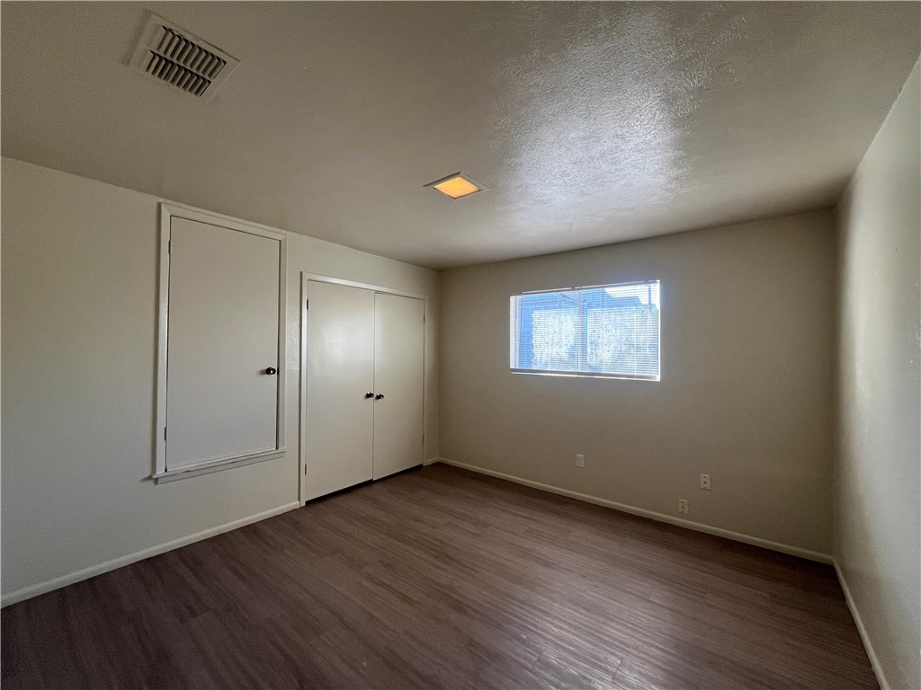 5002 Wingfoot Lane, Unit A Corpus Christi, TX 78413 - Photo 18 of 25 an empty room with wooden floor and windows