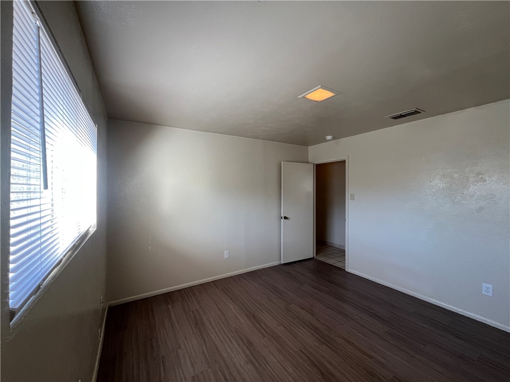 5002 Wingfoot Lane, Unit A Corpus Christi, TX 78413 - Photo 19 of 25 an empty room with wooden floor and windows