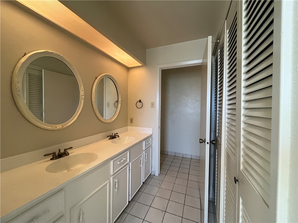 5002 Wingfoot Lane, Unit A Corpus Christi, TX 78413 - Photo 24 of 25 a bathroom with a double vanity sink and a mirror