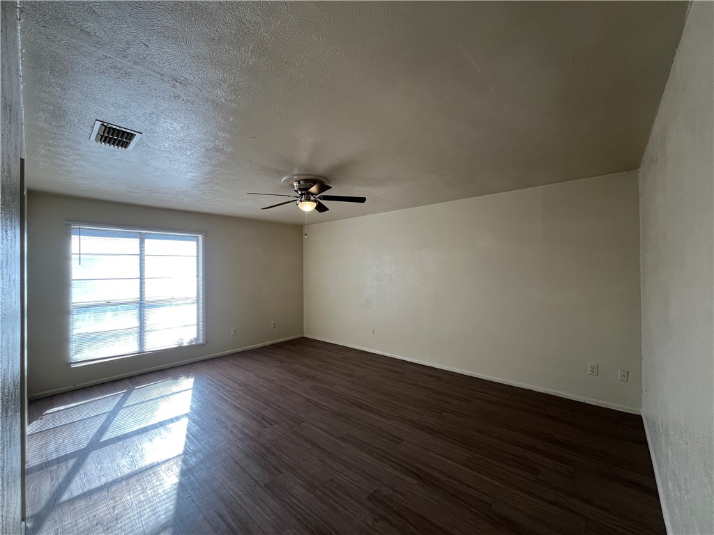5002 Wingfoot Lane, Unit A Corpus Christi, TX 78413 - Photo 9 of 25 an empty room with wooden floor and windows
