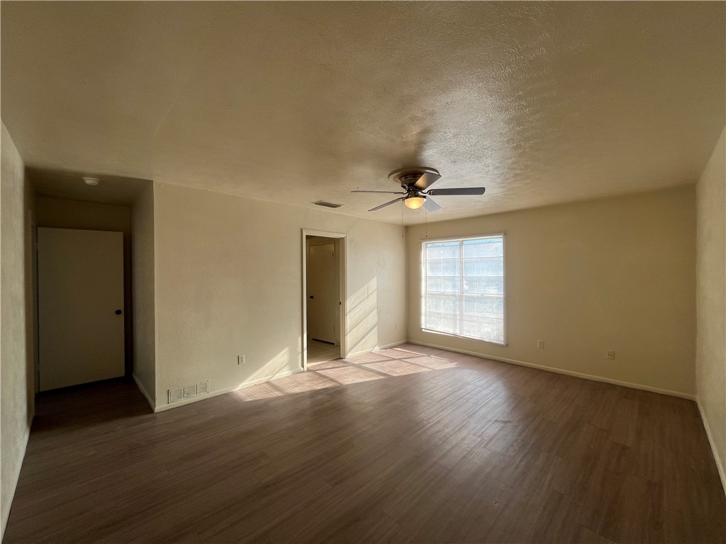 5002 Wingfoot Lane, Unit A Corpus Christi, TX 78413 - Photo 10 of 25 a view of an empty room with wooden floor and a window