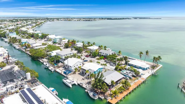 an aerial view of a house with a swimming pool and outdoor seating