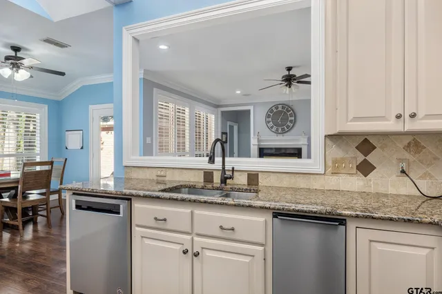 a kitchen with granite countertop a sink a stove and cabinets