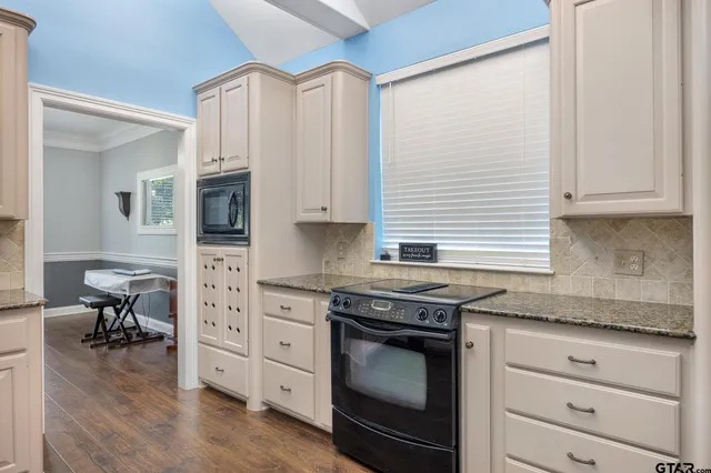 a kitchen with stainless steel appliances white cabinets and a stove top oven