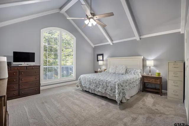 a spacious bedroom with a bed and a flat screen tv