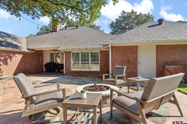 a view of a patio with table and chairs and wooden fence