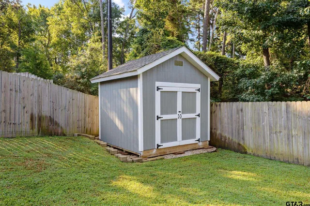 a view of backyard with barn and wooden fence