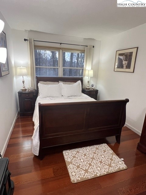 114 Lady Slipper Loop Newland, NC 28657 - Photo 25 of 50 a bedroom with a bed and wooden floor