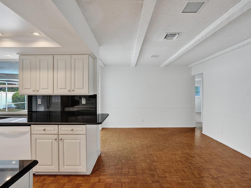 998 Southwest 5th Street Boca Raton, FL 33486 - Photo 30 of 55 a kitchen with granite countertop white cabinets and black appliances