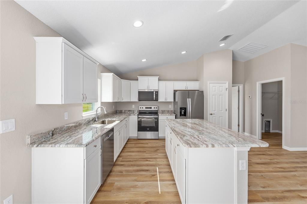 17654 Southwest 112th Lane Dunnellon, FL 34432 - Photo 5 of 17 a large kitchen with stainless steel appliances granite countertop a stove top oven a sink and dishwasher