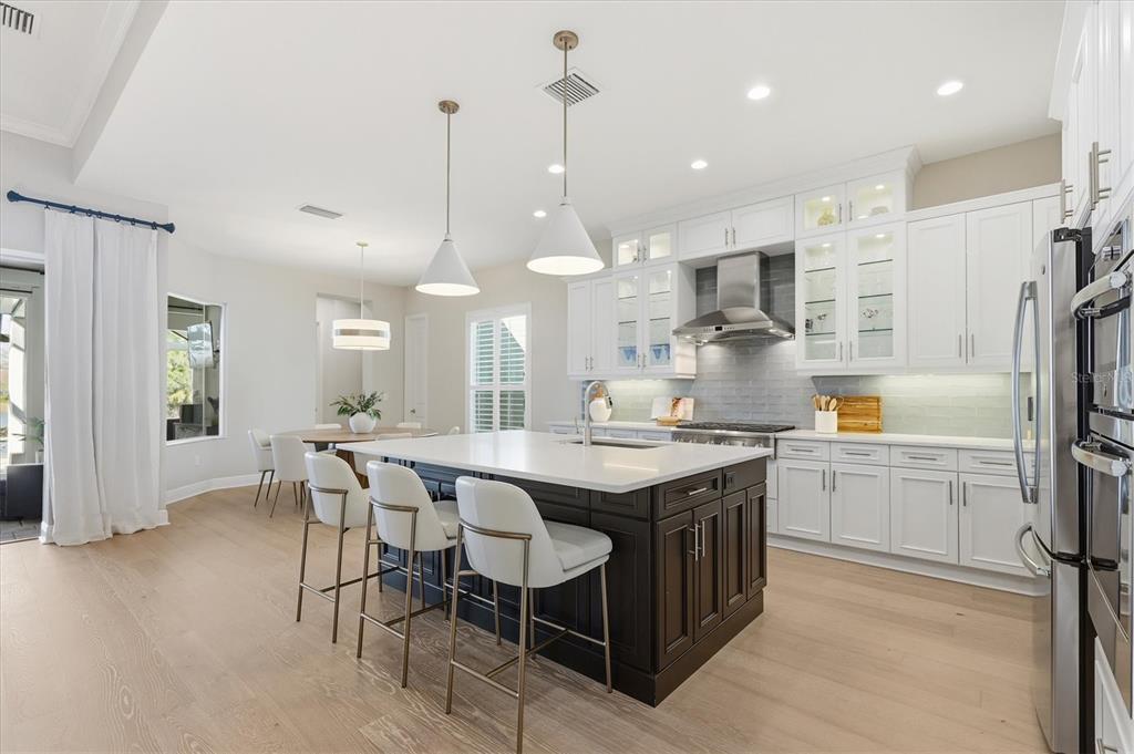 15909 Castle Park Terrace Lakewood Ranch, FL 34202 - Photo 16 of 66 a kitchen with kitchen island granite countertop a sink a center island and stainless steel appliances