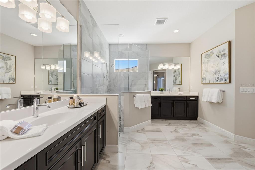 15909 Castle Park Terrace Lakewood Ranch, FL 34202 - Photo 24 of 66 a spacious bathroom with a double vanity sink a mirror and a bathtub