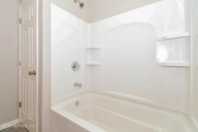 a white bath tub sitting next to a shower