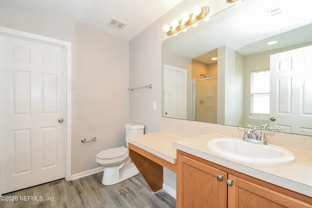 a bathroom with a sink a toilet and a large mirror