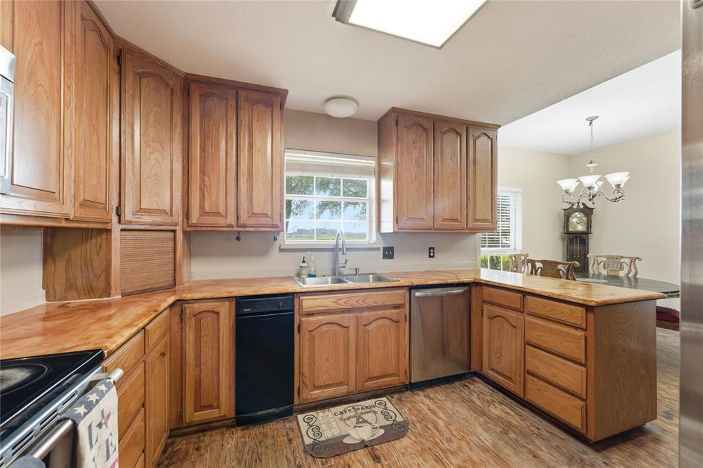 14529 County Road 511 Venus, TX 76084 - Photo 16 of 33 Kitchen with a peninsula, light countertops, and wood finish cabinetry
