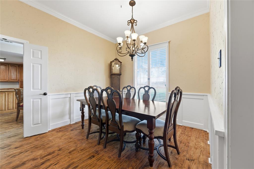 14529 County Road 511 Venus, TX 76084 - Photo 18 of 33 Dining room with ornamental molding, a wainscoted wall, suspended lighting, a decorative wall, and wood finished floors