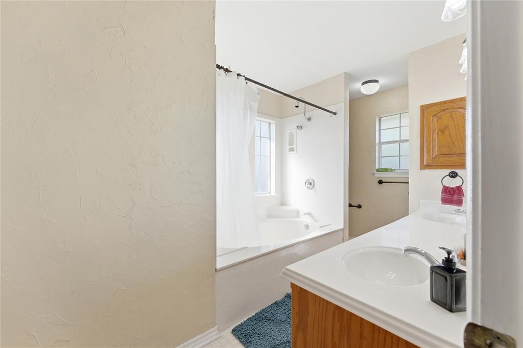 14529 County Road 511 Venus, TX 76084 - Photo 19 of 33 Bathroom with double vanity, shower / bath combo with shower curtain, and a textured wall