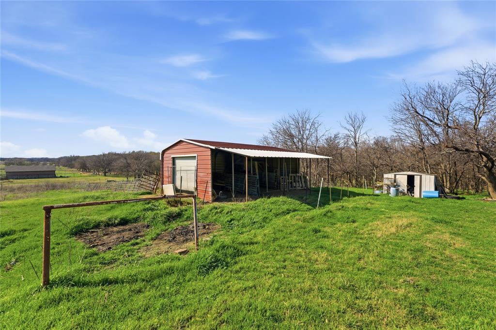 14529 County Road 511 Venus, TX 76084 - Photo 29 of 33 View of yard featuring an outdoor structure, a sunroom, a rural view, and a garage