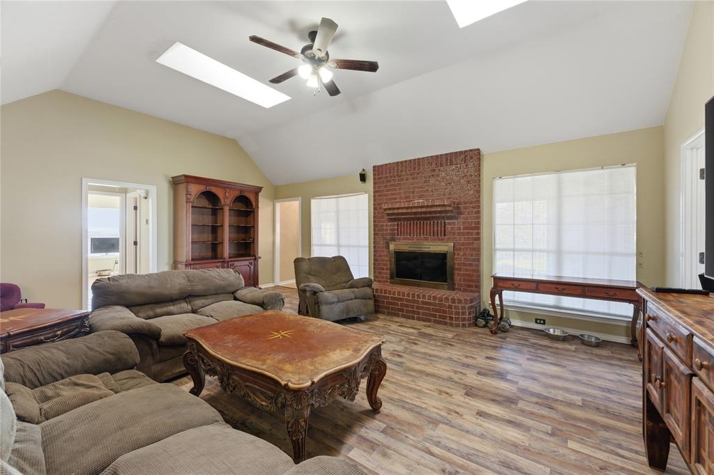 14529 County Road 511 Venus, TX 76084 - Photo 4 of 33 Living area with a skylight, light wood-style flooring, ceiling fan, and a brick fireplace