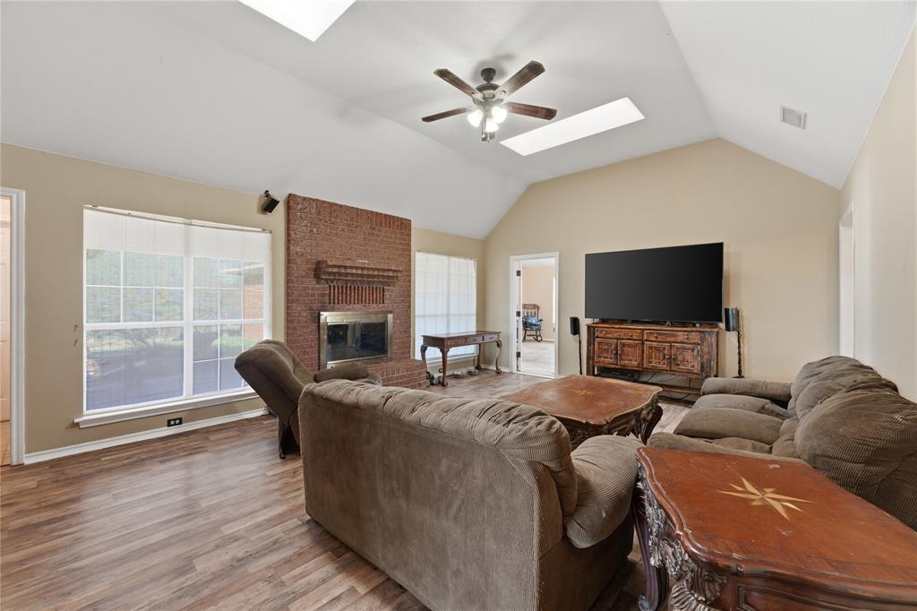 14529 County Road 511 Venus, TX 76084 - Photo 9 of 33 Living room featuring a skylight, ceiling fan, wood finished floors, and a fireplace