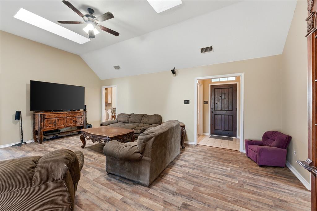 14529 County Road 511 Venus, TX 76084 - Photo 10 of 33 Living room featuring a skylight, lofted ceiling, ceiling fan, and light wood-style floors