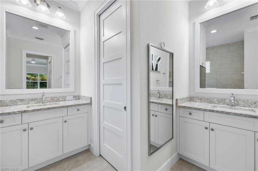5797 Anegada Drive Naples, FL 34113 - Photo 18 of 40 a spacious bathroom with a granite countertop sink and a mirror