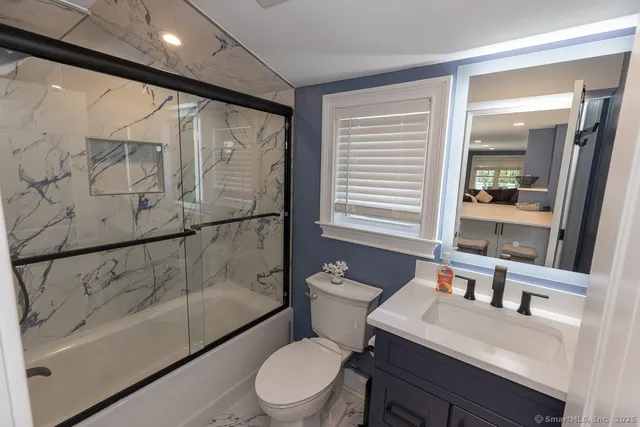 a bathroom with a sink a toilet and shower