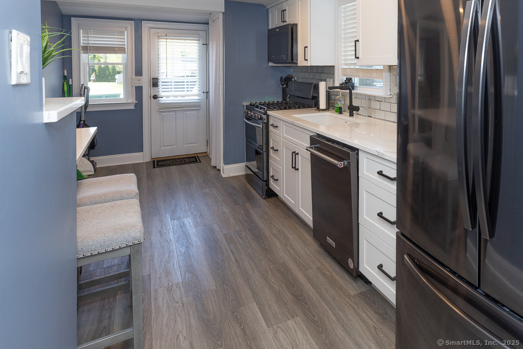 55 Swan Avenue Old Lyme, CT 06371 - Photo 17 of 40 a kitchen with kitchen island wooden floors appliances and cabinets