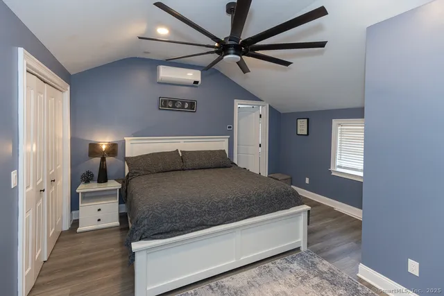 a spacious bedroom with a bed and a ceiling fan
