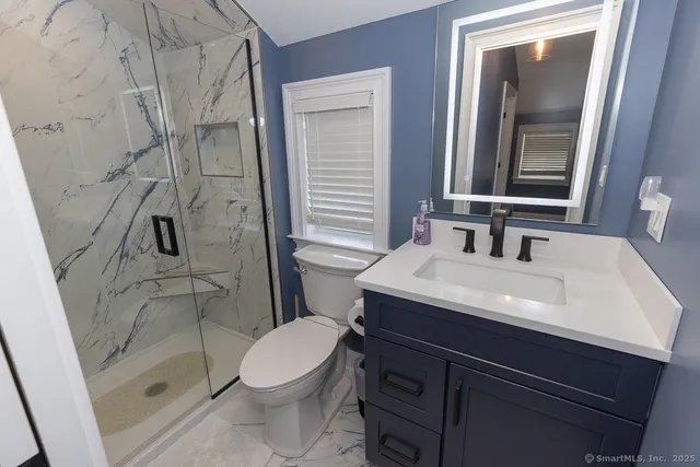 a bathroom with a sink a toilet and shower