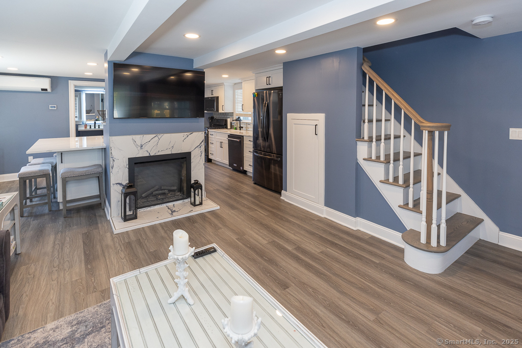 55 Swan Avenue Old Lyme, CT 06371 - Photo 6 of 40 a living room with furniture a flat screen tv and a fireplace