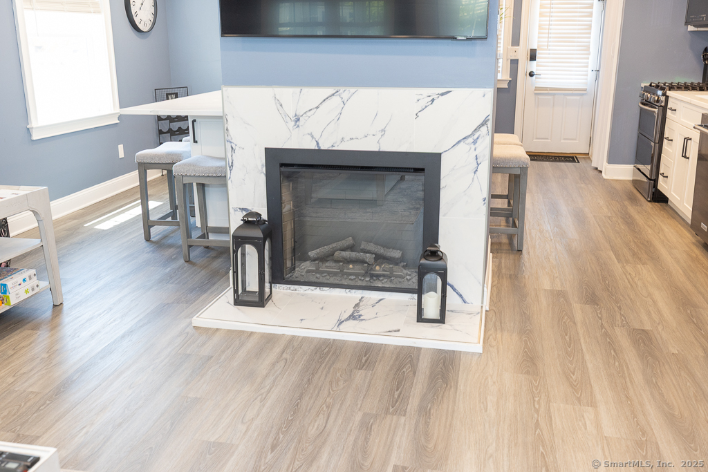 55 Swan Avenue Old Lyme, CT 06371 - Photo 8 of 40 a living room with a wooden floor and a fireplace