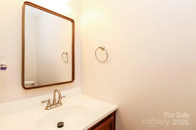 a bathroom with a granite countertop sink a toilet and a mirror
