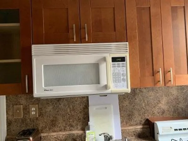 a kitchen with granite countertop a sink a stove and wooden cabinets