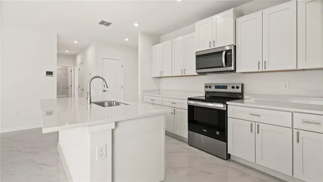 a kitchen with white cabinets and stainless steel appliances