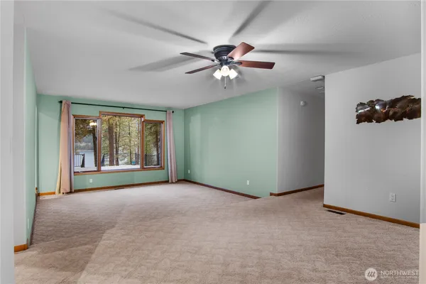 a view of a livingroom with a ceiling fan and window