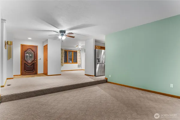 an empty room with window and a ceiling fan