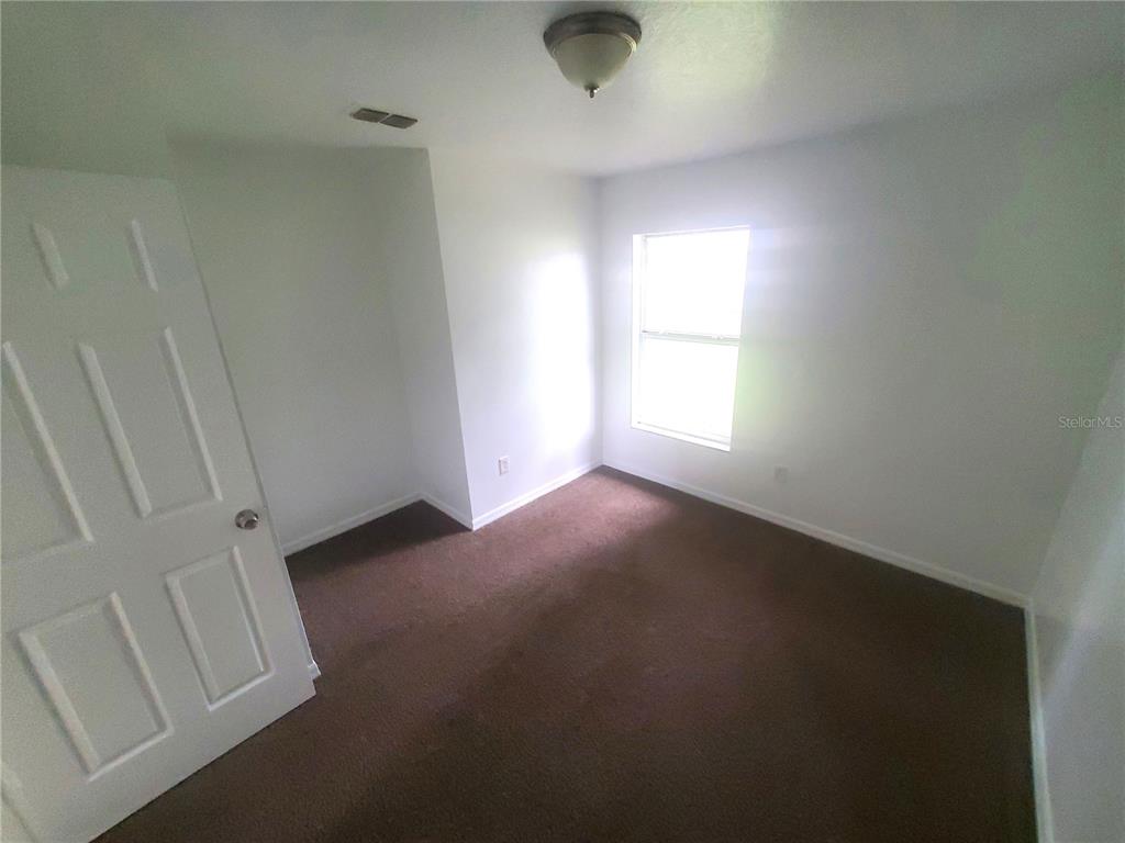 13589 Southwest 107th Place Dunnellon, FL 34432 - Photo 5 of 8 a view of empty room with windows