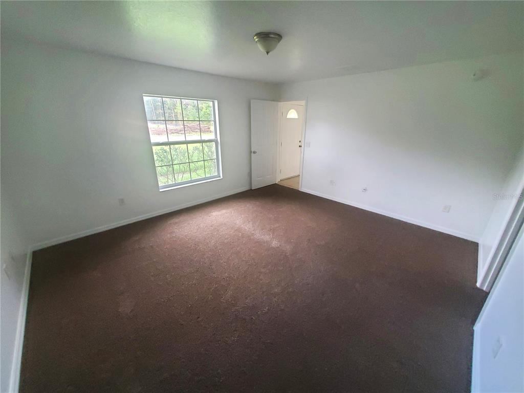 13589 Southwest 107th Place Dunnellon, FL 34432 - Photo 7 of 8 an empty room with windows