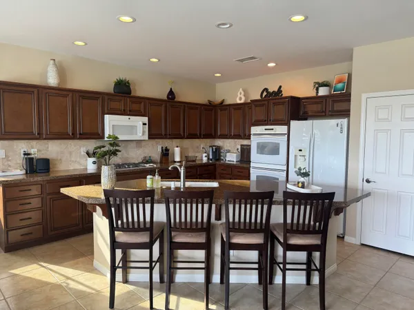 a kitchen with a refrigerator and a stove top oven
