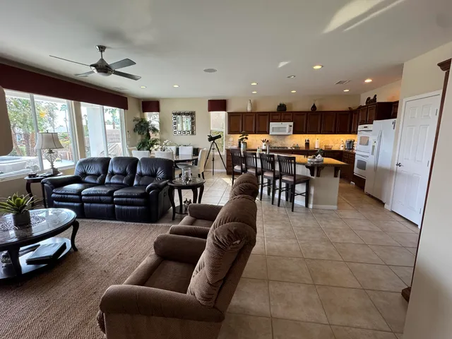 a living room with flat screen tv and floor to ceiling window